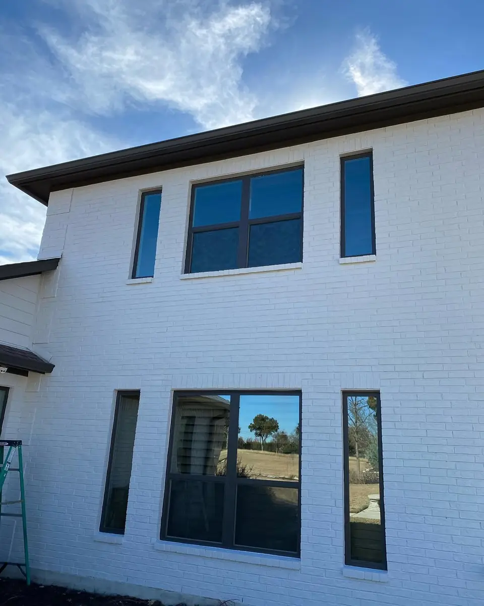 Tall rear elevation of white brick home painted by New Life Painting